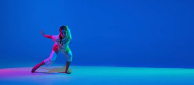 Beyaz elbiseler içinde dans eden güzel kız mavi arka planda neon ışıkta