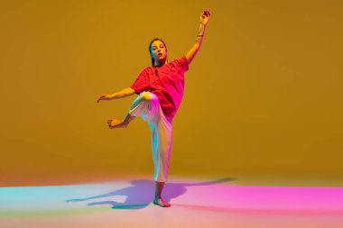 Arka planda neon ışıklarıyla hip-hop yapan sportif kız.