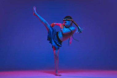 Genç Taylandlı boksör mavi arka planda neon ışıkta eğitim görüyor..