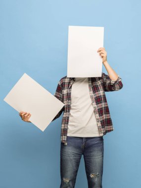 Mavi arka planda boş kağıt yaprakları olan genç bir adamın portresi.