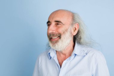 Açık mavi arkaplan üzerinde izole edilmiş yaşlı gri saçlı adamın yakın plan portresi..