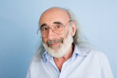 Yakın plan yaşlı gri saçlı gözlüklü adam açık mavi arka planda izole edilmiş..