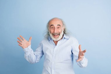 Açık arkaplanda izole edilmiş yaşlı, gri saçlı bir adamın yarım boy portresi..