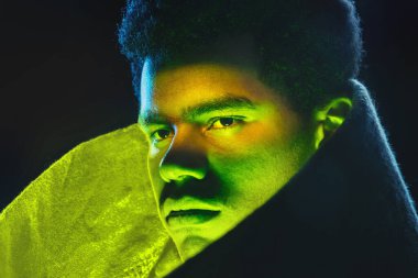 Siyah arka planda sarı parıltılı, neon ışıklı Afro-Amerikan bir adam kapatın..