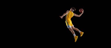 Siyah arka planda izole edilmiş genç Kafkas basketbol oyuncusu eğitimi.