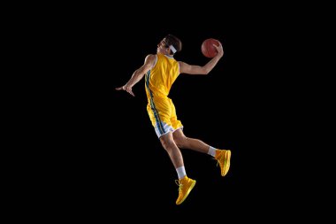 Siyah arka planda izole edilmiş genç Kafkas basketbol oyuncusu eğitimi.