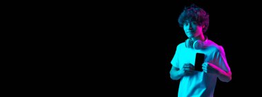 Kafkasyalı genç adam telefon ekranı gösteriyor. Neon rengi arka planda izole edilmiş.