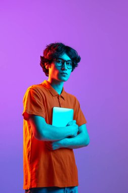 Aygıtlı gözlüklü genç adam neon arka planda izole edilmiş.