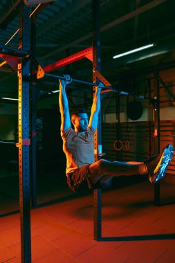 Genç atletik adam, beden eğitimi hocası karışık neon ışıkta..