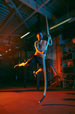 Genç atletik adam, beden eğitimi hocası karışık neon ışıkta..