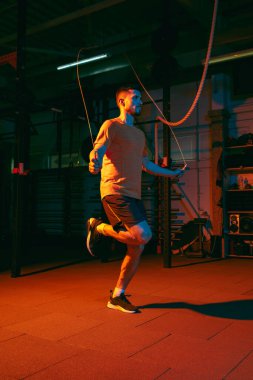 Genç atletik adam, beden eğitimi hocası karışık neon ışıkta..