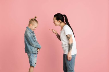 İki kişi, anne ve oğlu pembe arka planda izole bir şekilde konuşuyorlar..