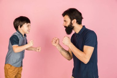 Beyaz adam ve küçük çocuk, baba ve oğul pembe arka planda izole edilmiş..