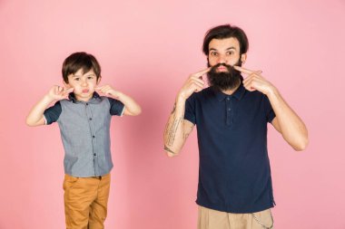 Beyaz adam ve küçük çocuk, baba ve oğul pembe arka planda izole edilmiş..
