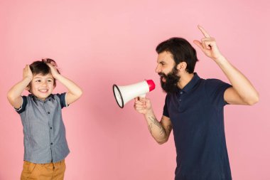 Genç adam ve küçük çocuk, baba ve oğul pembe arka planda izole edilmiş..