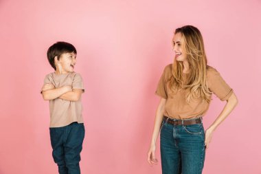 Mutlu kadın ve küçük çocuk, anne ve oğul pembe arka planda izole edilmiş..