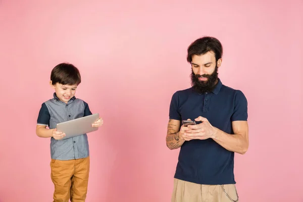 Hombre caucásico y niño pequeño, padre e hijo aislados sobre fondo rosa. — Foto de Stock