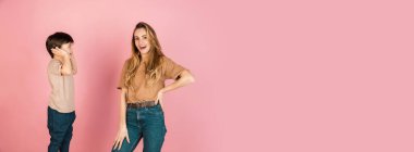 Mutlu kadın ve küçük çocuk, anne ve oğul pembe arka planda izole edilmiş..