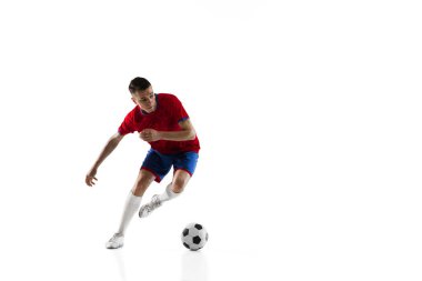 Beyaz arka planda genç beyaz futbolcu eğitimi.