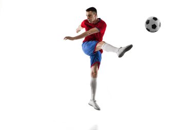 Beyaz arka planda genç beyaz futbolcu eğitimi.