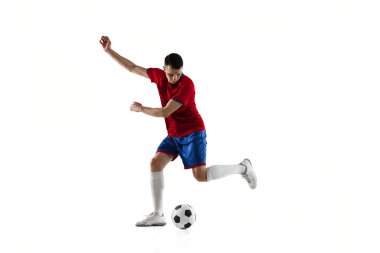 Beyaz arka planda genç beyaz futbolcu eğitimi.