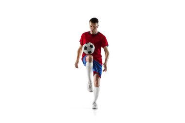 Genç futbolcu eğitiminin portresi beyaz arka planda izole edildi.