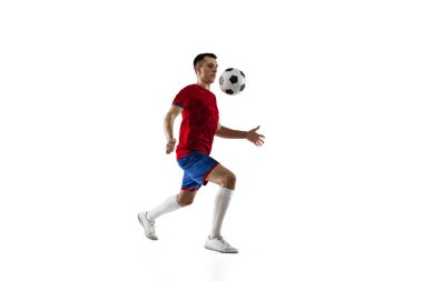 Genç futbolcu eğitiminin portresi beyaz arka planda izole edildi.