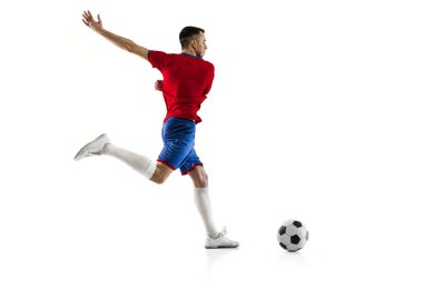Beyaz arka planda genç beyaz futbolcu eğitimi.