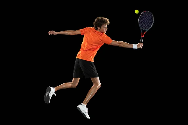 Jovem caucasiano, tenista treinando isolado em fundo preto. — Fotografia de Stock