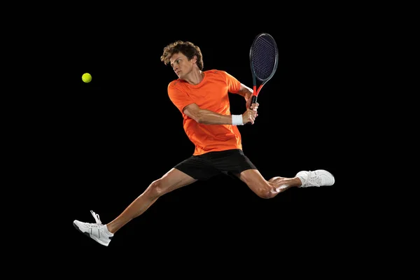 Junger kaukasischer Mann, Tennisspieler trainiert isoliert auf schwarzem Hintergrund. — Stockfoto