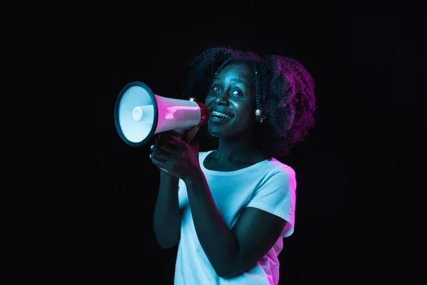 Młoda piękna Afroamerykanka odizolowana na ciemnym tle w neonowym świetle — Zdjęcie stockowe