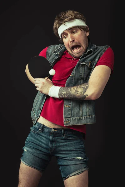 Jovem caucasiano engraçado homem jogando ping pong isolado no fundo preto. — Fotografia de Stock