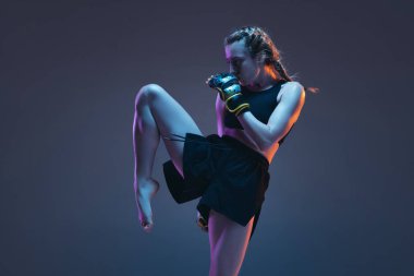 Beyaz kadın dövüşçü eğitimi mavi arka planda neon ışıkta izole edilmiş.