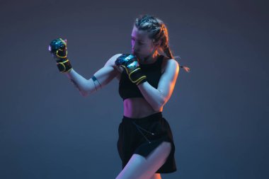 Beyaz kadın dövüşçü eğitimi mavi arka planda neon ışıkta izole edilmiş.