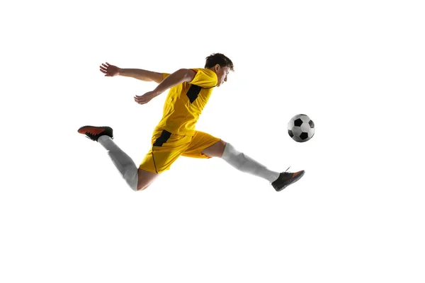 Jeune homme, joueur de football masculin s'entraînant isolé sur fond blanc. — Photo
