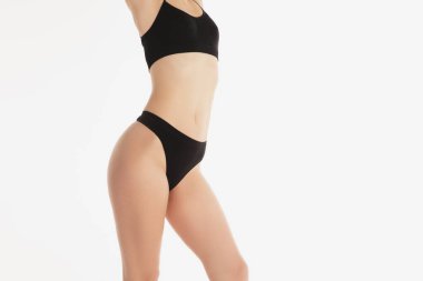 Beyaz arka planda siyah iç çamaşırlı güzel bir kadın vücudu..