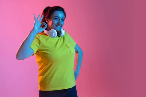 Retrato de hermosa mujer feliz aislado sobre fondo rosa en luz de neón —  Fotos de Stock