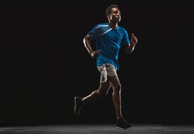 Siyah arka planda izole edilmiş genç bir Afro-Amerikan sporcu..