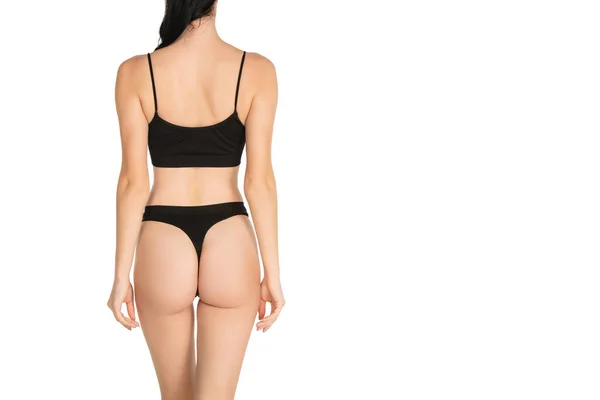 Vista trasera del cuerpo femenino delgado en ropa interior negra sobre fondo blanco. —  Fotos de Stock