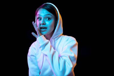 Beyaz tenli güzel bir kız karanlık arka planda neon ışıkta izole edilmiş.