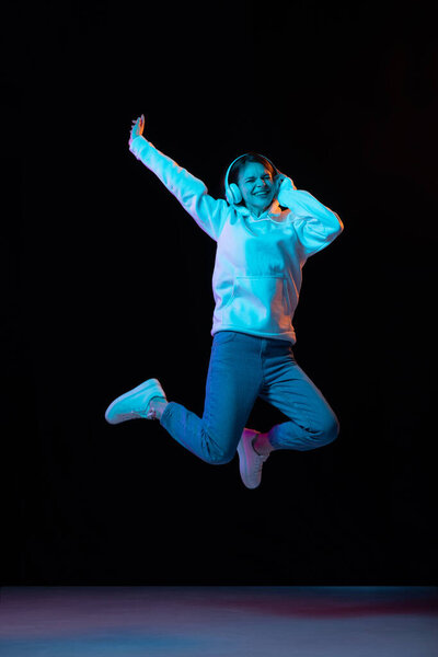 Полнометражный портрет молодой красивой девушки на тёмном фоне.