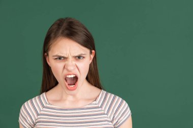 Yeşil arka planda izole edilmiş genç beyaz kadın portresi.