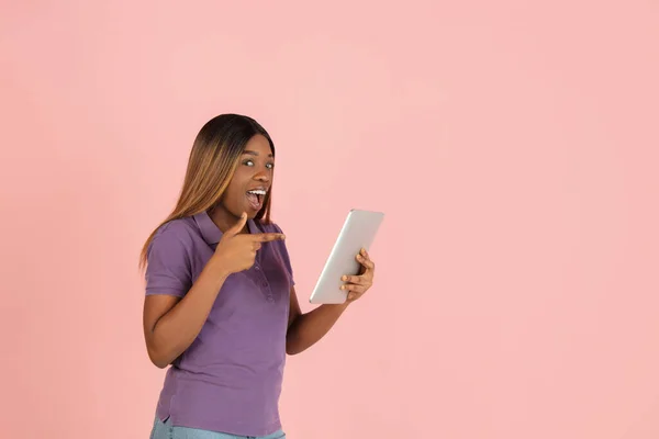 Een flyer. Portret van Afrikaanse vrouw poseren geïsoleerd op roze achtergrond. — Stockfoto