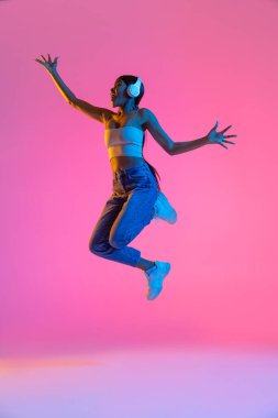 Pembe arka planda izole edilmiş güzel bir kızın tam boy portresi.