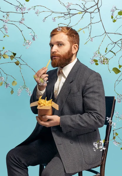 Portrait de jeune homme à la tête rouge et barbu agissant artiste célèbre isolé sur fond bleu floral — Photo