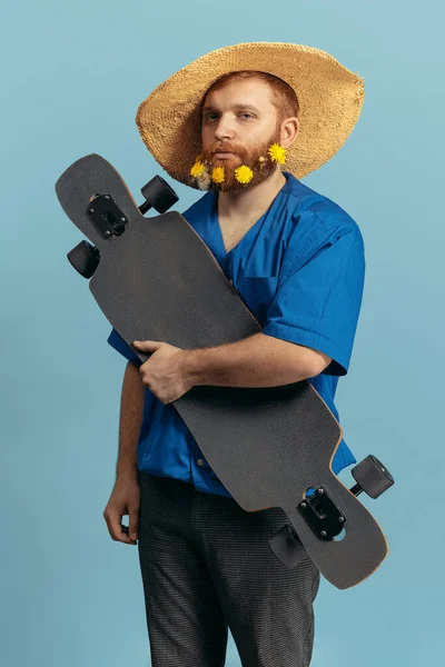 Ung rödhårig och skäggig man i halmhatt som står isolerad över blå bakgrund. Jämförelse med fel — Stockfoto