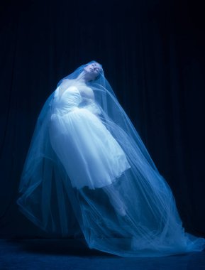 Genç, zarif balerina, sanat performansında hayalet gelin görüntüsü. Karanlık arka planda, neon ışıkta izole edilmiş..