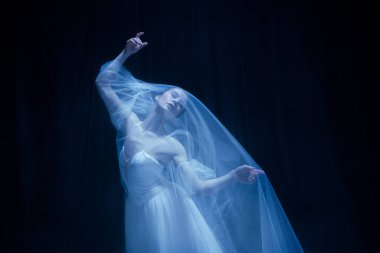 Umutsuzluk. Genç, zarif balerina, sanat performansında hayalet gelin görüntüsü. Karanlık arka planda, neon ışıkta izole edilmiş..