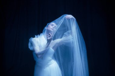 Yalnızlık. Genç zarif güzel kadın, beyaz gelinlik içinde balerina, sanat performansı..