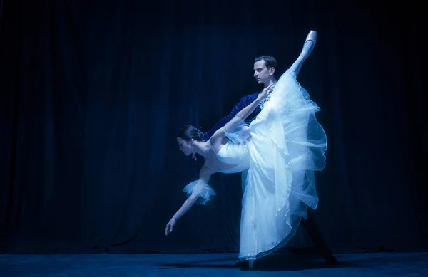 Mujer joven en vestido de novia y hombre, dos bailarines de ballet en performance de arte bailando aislados sobre fondo oscuro. — Foto de Stock